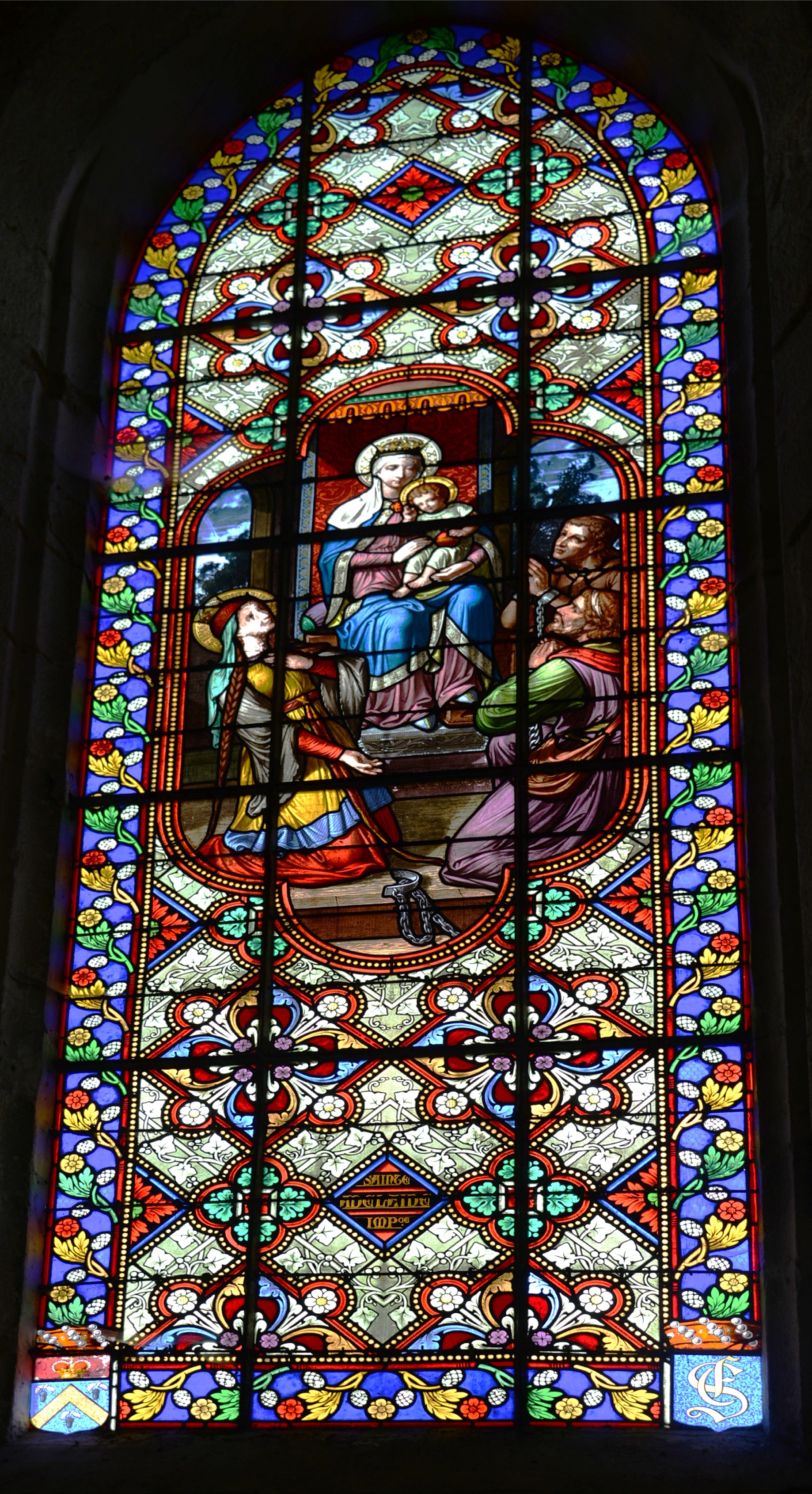 Vitrail Ste Adélaïde demande à la Vierge Marie de libérer les prisonniers.Église de Jouy-le-Châtel - Repère 11Don de Édouard de SilvestreOn remarquera les armes de la famille en bas à gauche et les initiales S entrelacé d'un E et d'un F en bas à droite. S (Silvestre) entrelacé d'un E (Édouard et Emma) et d'un F (Franz et Fanny) en bas à droite.Marie-Fanny, Adélaïde-Emma et Franz sont les trois enfants d'Édouard.Vitrail dédié à Adélaïde Emma.